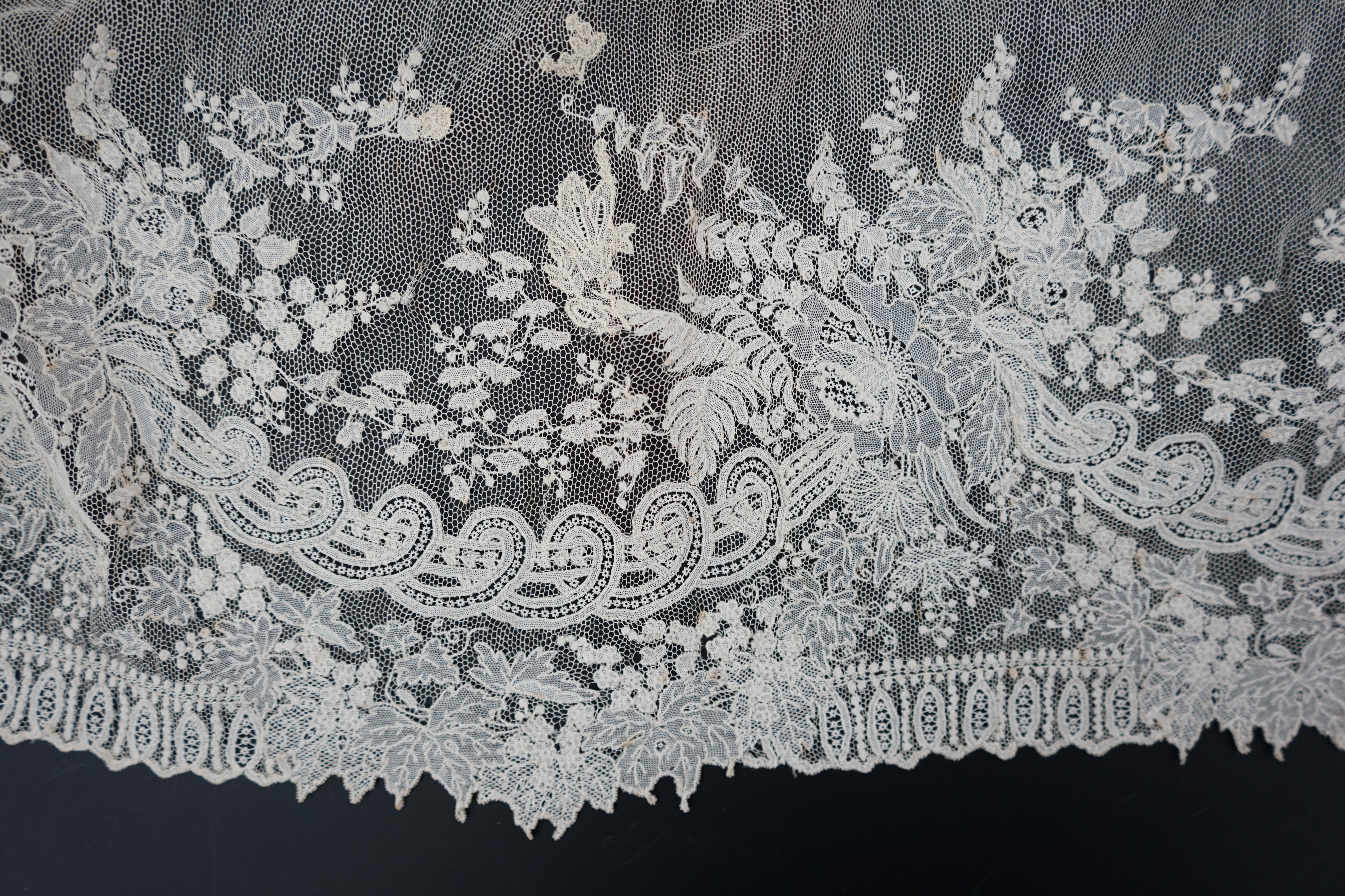 A 19th century Brussels Point de gaze needle lace stole 228cm long x 37cm wide, made from two lengths of the same patterned lace, invisibly joined along the centre of the stole, the raw end edges carefully finished with